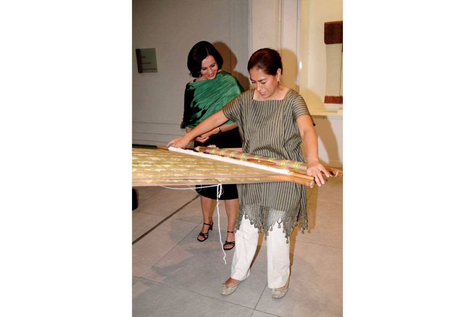 Guadalupe de Vázquez Mota y artesana tejiendo en telar de cintura en la presentación del libro Arte del Pueblo, Manos de Dios en el Museo de Arte Popular. (Foto: AmigosMAP).